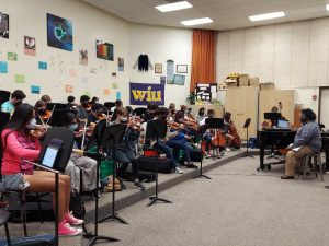 Chester leads the symphony orchestra during class.