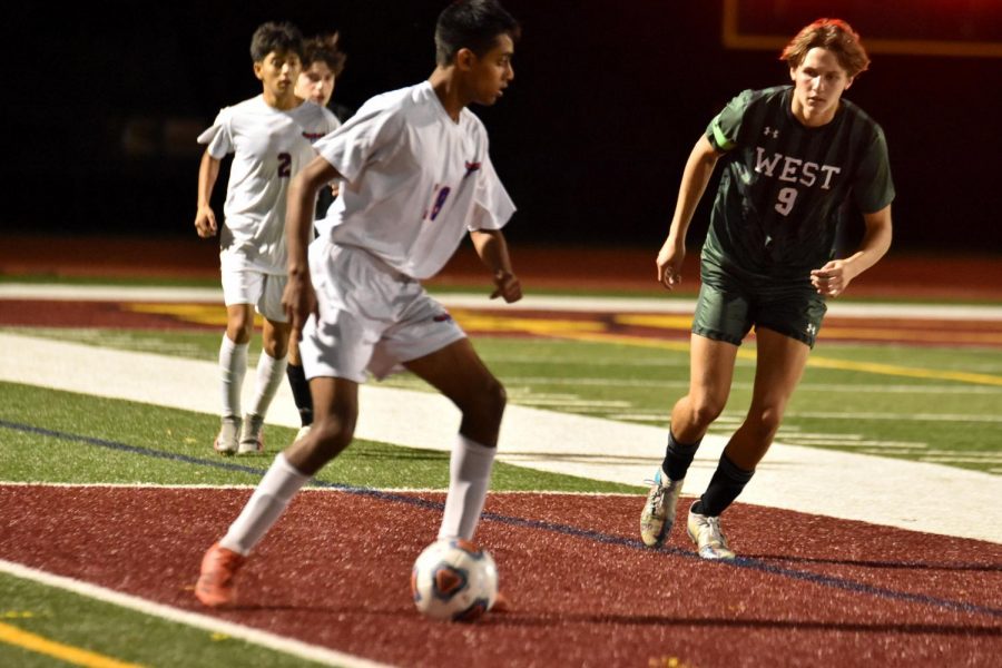 Anand Krishnan shields the ball from oncoming defender.