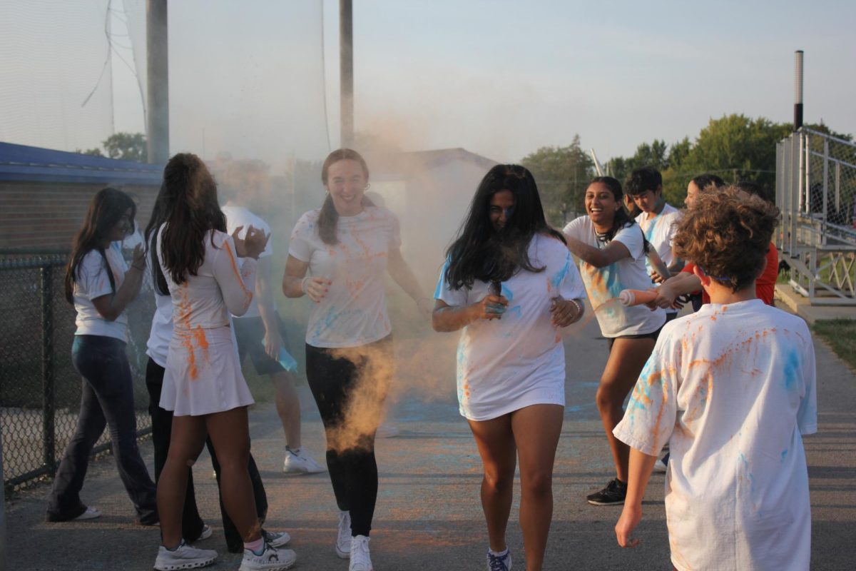 Students, including Emmersen Lennert and Ananya Krishnan, enjoy being splashed with multiple colors as they participate in the Color Run.